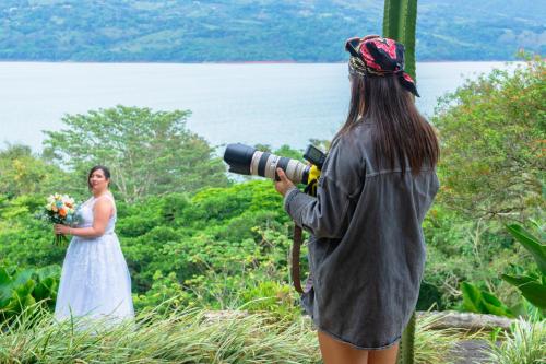 a woman taking a picture of a bride with a camera at Lake Arenal Hotel & Brewery in Tilarán