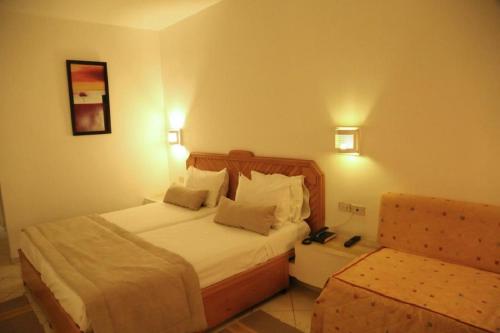 a hotel room with a bed and a chair at Golf Residence- Families and Couples Only in Hammam Sousse
