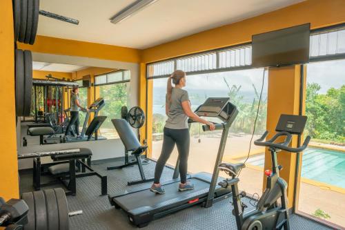 a woman on a treadmill in a gym at Lake Arenal Hotel & Brewery in Tilarán