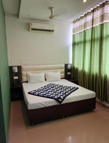 a bedroom with a large bed with a green curtain at Hotel Green Land in Mohali