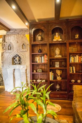 a living room with a book shelf and a plant at Avalon Ubud Castle & SPA in Ubud