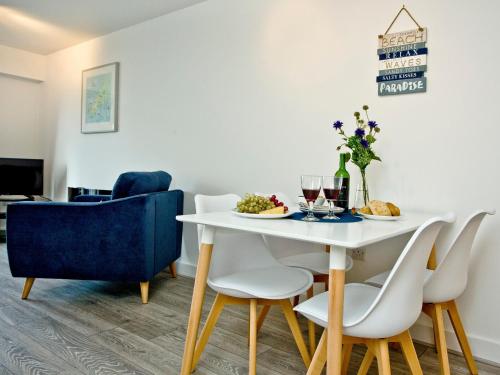 a dining room with a white table and chairs at Fistral Escape in Crantock