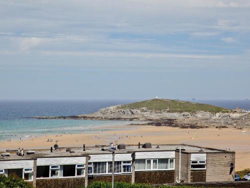 a beach with a building and people on the beach at Fistral Escape in Crantock