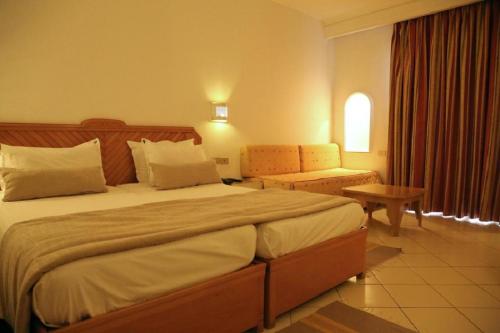 a hotel room with a large bed and a chair at Golf Residence- Families and Couples Only in Hammam Sousse
