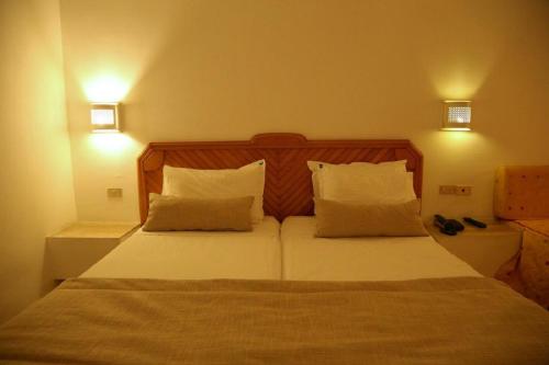 a bedroom with a bed with white sheets and pillows at Golf Residence- Families and Couples Only in Hammam Sousse