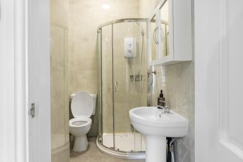 ein Badezimmer mit Dusche, Toilette und Waschbecken in der Unterkunft Newly renovated 3 Ensuite bedroom house in bury, 5 people in Bury