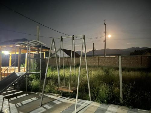 a swing set in a field of grass at night at Mountain View in Kochkor