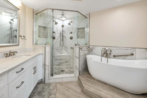 a white bathroom with a tub and a shower at St. Simons Grand #120 in Saint Simons Island