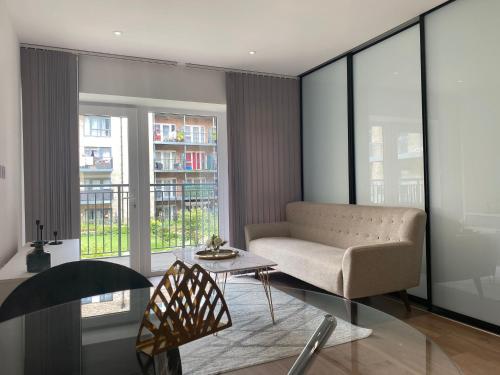 a living room with a couch and a table at Sunny Gardens 3-Bed Apartment in London in Hendon