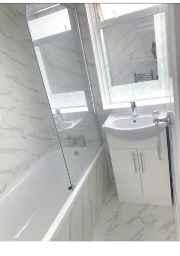 a white bathroom with a shower and a sink at Sunny Gardens 3-Bed Apartment in London in Hendon