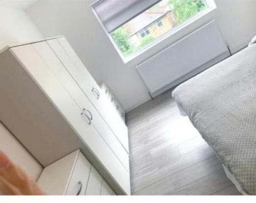 a room with a bed and a window and a floor at Sunny Gardens 3-Bed Apartment in London in Hendon