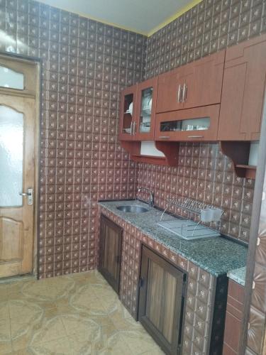 a kitchen with wooden cabinets and a counter top at Guest house maka in Gonio