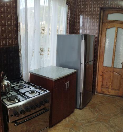 a kitchen with a stove and a refrigerator at Guest house maka in Gonio