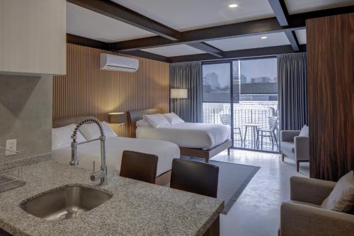 a hotel room with two beds and a bathroom at MX Grand Suites in Mexico City