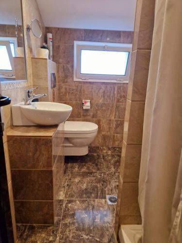 a bathroom with a sink and a toilet and a window at Apartments Vesna Luxury & Stefan ap 4 in Paralia Katerinis