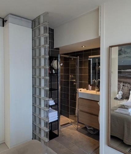 a bathroom with a shower and a sink at Strandstudio Lumare in Bergen aan Zee