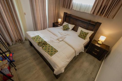 a bedroom with a large bed with a woman on it at Airgo Residences in Kigali
