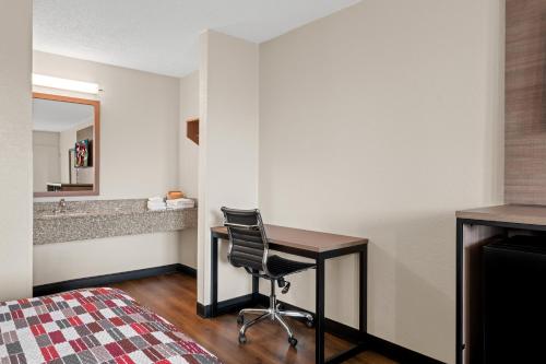 a bedroom with a desk and a chair in a room at Red Roof Inn Charlotte - Airport in Charlotte