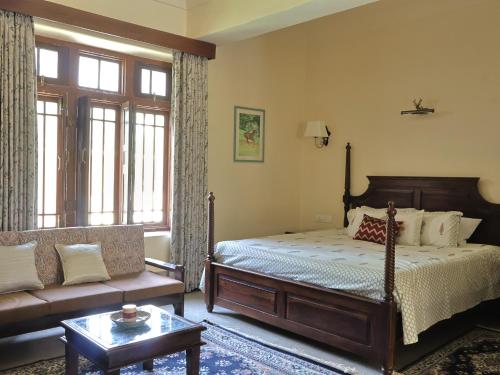 a bedroom with a bed and a couch at Mundoota House in Jaipur