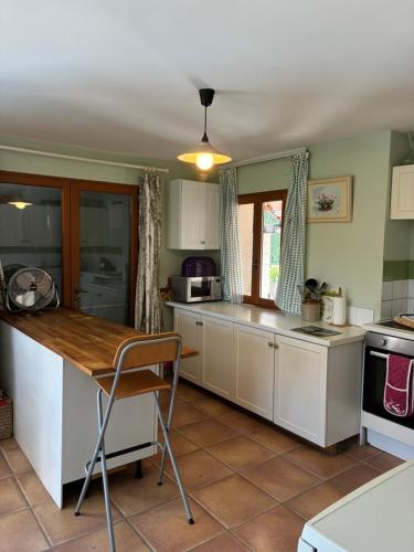 a kitchen with white cabinets and a wooden counter top at Vacation home with pool in Quillan