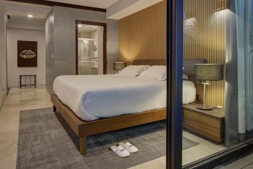 a bedroom with a large bed with white sheets at MX Grand Suites in Mexico City