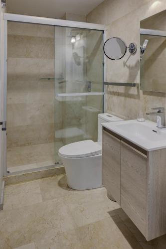 a bathroom with a toilet and a shower and a sink at MX Grand Suites in Mexico City