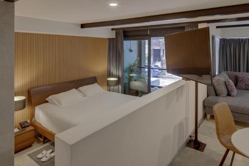 a bedroom with a bed and a tv and a couch at MX Grand Suites in Mexico City