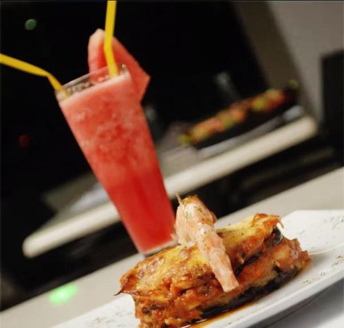 a plate of food with shrimp and a drink at Hotel Aventura Suites Tucacas in Tucacas