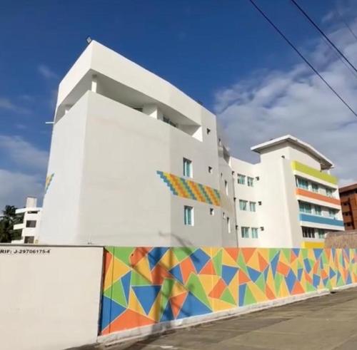 a white building with a colorful mural on the side of it at Hotel Aventura Suites Tucacas in Tucacas