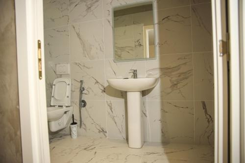 a bathroom with a sink and a toilet at Greco Boutique Hotel in Shkodër