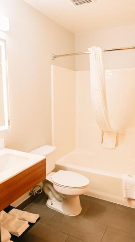 a white bathroom with a toilet and a sink at Microtel Inn & Suites by Wyndham Gulf Shores in Gulf Shores