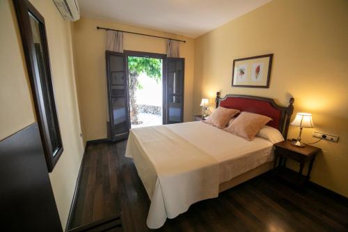 a bedroom with a bed and a door to a patio at Villa Turistica de Bubion in Bubión