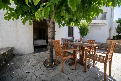a wooden table and chairs under a tree at Villa Turistica de Bubion in Bubión