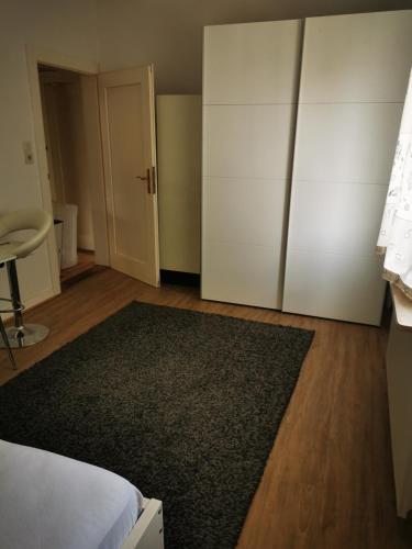 a bedroom with a white closet and a black rug at Ferienwohnung Zimmer in Darmstadt