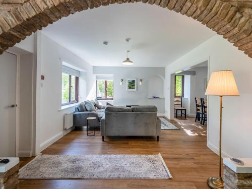 una sala de estar con un sofá y una mesa en The Farmhouse, en Hawes