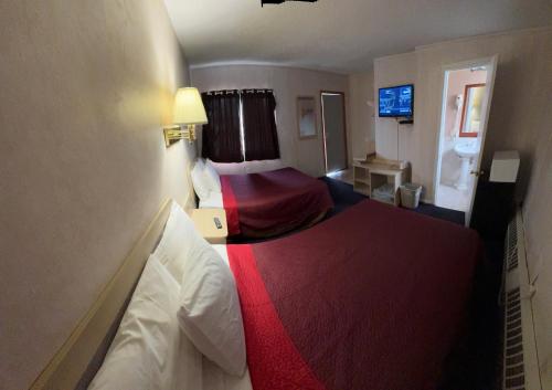 a hotel room with two beds with red sheets at Sands Motel Niagara Falls in Niagara Falls