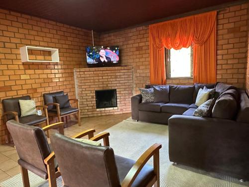 a living room with a couch and a fireplace at Pousada Esperança in Osório