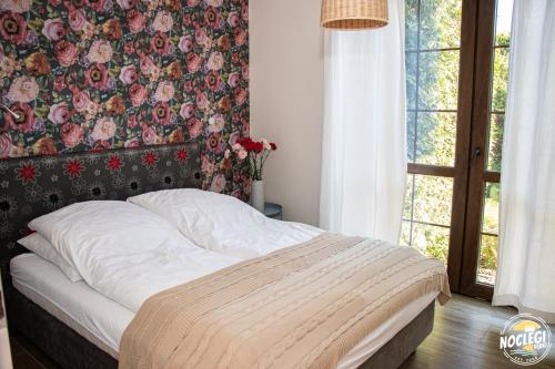 a bed in a bedroom with a floral wall at Azyl in Dębki