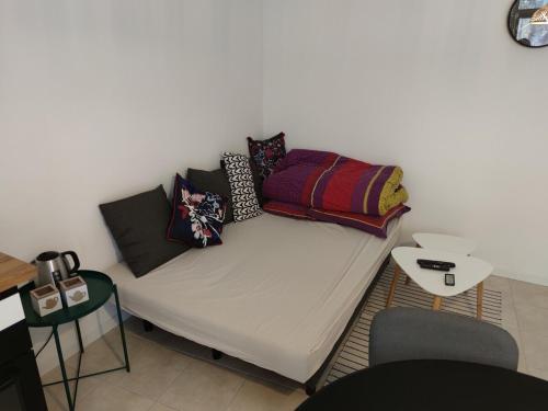 a couch with pillows on it in a room at Studio de charme, au calme dans le vieux Chaumont in Chaumont