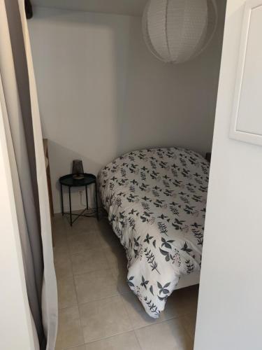a small bedroom with a bed with a black and white blanket at Studio de charme, au calme dans le vieux Chaumont in Chaumont