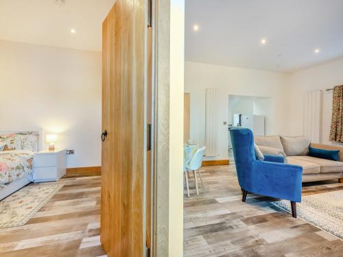 a living room with a couch and a blue chair at Ty Gwair - Uk41512 in Llanfair Clydogau