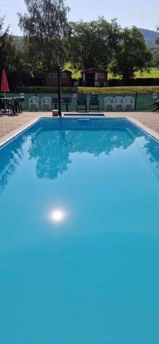 a blue swimming pool with chairs and a table at Hotel Formule in Děčín