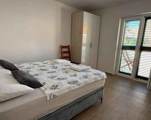 une chambre avec un lit, une chaise et des fenêtres dans l'établissement True Apartment Jure - FREE Boat Trip for 7 or more Nights!, à Biograd na Moru