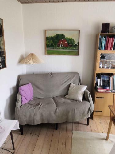 a living room with a couch and a lamp at Family Holiday Near Beach, Town And Nature in Svaneke