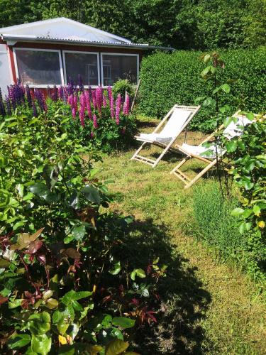 a garden with a chair and some purple flowers at Family Holiday Near Beach, Town And Nature in Svaneke