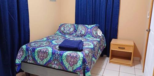 a small bedroom with a bed with a blue blanket at Villas del Edén in El Pino