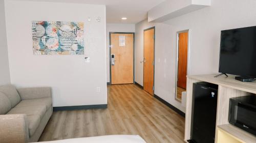a living room with a couch and a flat screen tv at Microtel Inn & Suites by Wyndham Gulf Shores in Gulf Shores