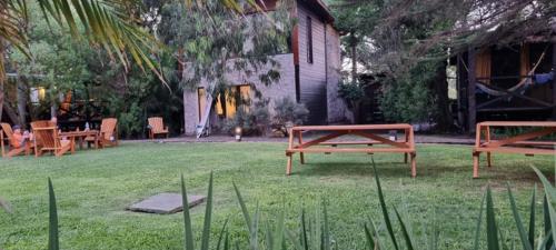 two picnic tables and chairs in a yard at Complejo Aramis Chapadmalal in Chapadmalal