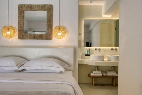 a bedroom with a bed with a mirror and a sink at Nodo Boutique Hotel in Mýkonos City