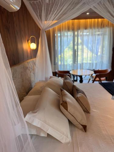 a bedroom with a white bed with pillows at Quinta da Bocaina in Amparo